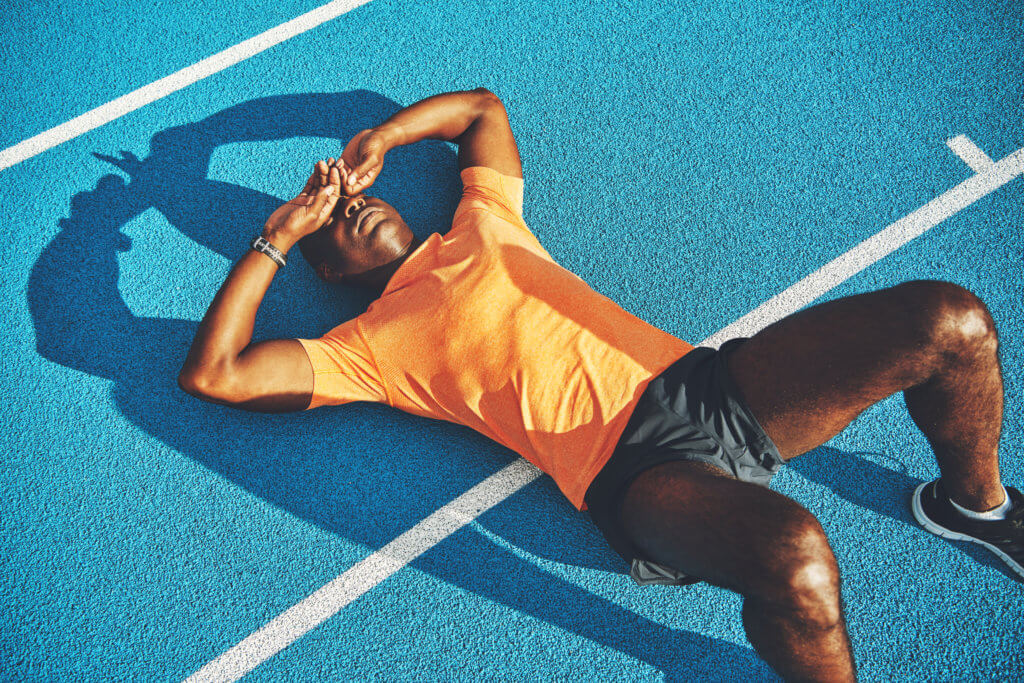 Tired athlete lying on track
