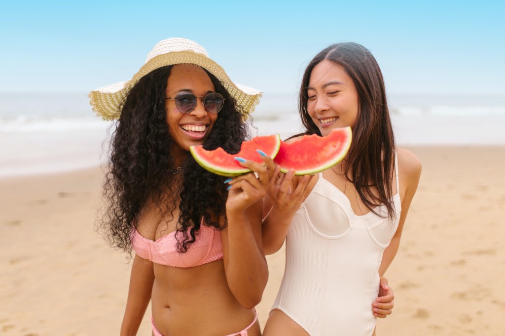 Women eating watermelon on the beach